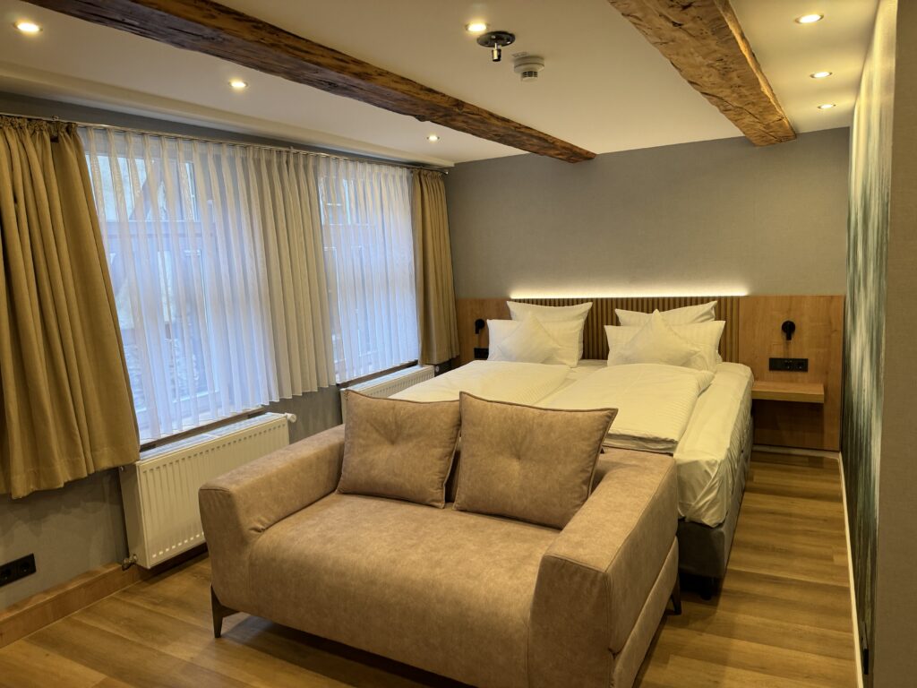Familienzimmer mit Doppelbett, Sofa und historischen Deckenbalken